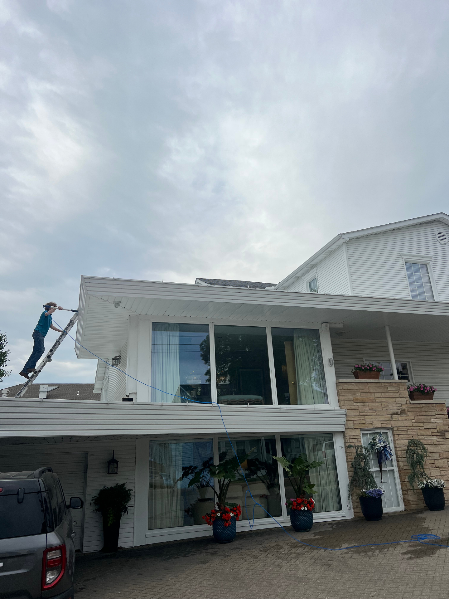 Jackson cleaning second-story windows with a water-fed pole